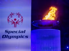 Das Logo der Special Olympics auf einer Fahne neben der olympischen Flamme. (Foto: picture alliance/dpa | Christoph Soeder)